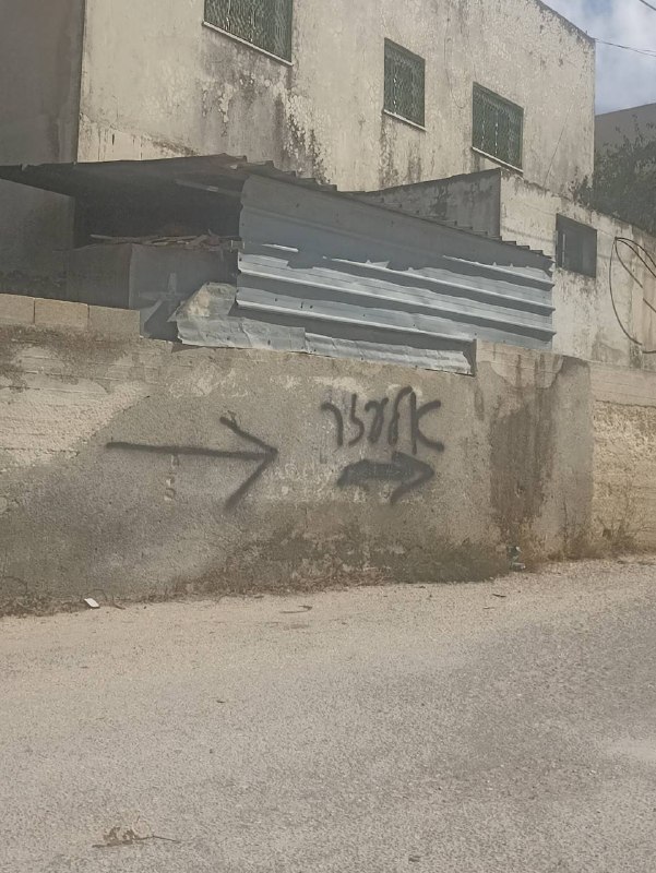 Following settlers who write their slogans on the way to Makam al-Uzir in the western neighborhood in the town of Awarta, south of Nablus.