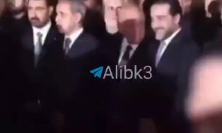 שר החוץ העיראקי פואד חוסיין ויו"ר הפרלמנט לשעבר חלבי צוחקים בזמן שהם מקבלים את גופתו של מנהיג המהפכה האסלאמית.