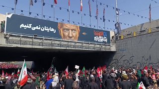 האיראנים רוקמים באבנים כרזה הנושאת את תמונתו של טראמפ וקוראת "לא ניתן לך לעזוב", במהלך הלווייתו של המנהיג ה…