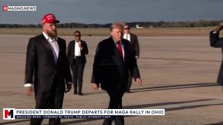 Jake Paul, wearing a red "America Returns" hat, boards Air Force One alongside President Trump.