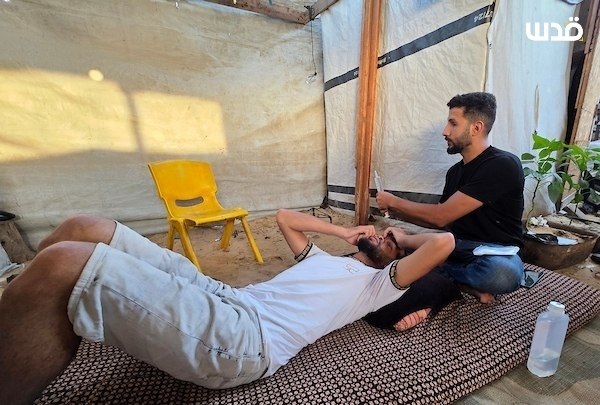 שני האחים, מוחמד דאבור ומוסא דאבור, חיים בתוך אוהל עקירה בחאן יונס, לאחר שנפגעו מכדורי כיבוש במרכז לחלוקת ס…