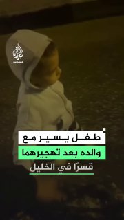 ילד הולך אוחז בידו של אביו לאחר שכוחות ישראל אילצו אותם לפנות בכוח את ביתם באזור אל-ג'לדה ועין דיר בהא בעיר…