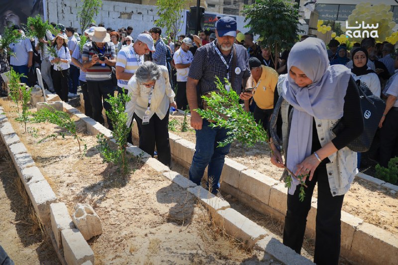 המשתתפים באירוע "השיחה הסורית החמישית" מבקרים בבית הקברות של חללי הטבח הכימי בזמלקה באזור הכפר של דמשק, שבי…