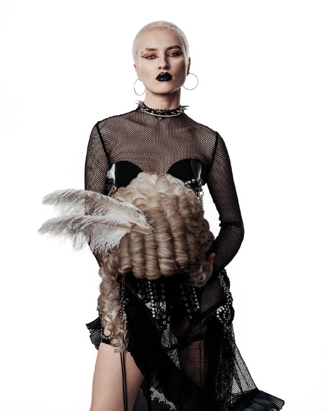 Съемка «панк 18 века» или «Антуанетта в конверсах», не сложно догадаться по теме, что мы выбрали работу с париками. Долго думала и в итоге решила — пора делиться знаниями о париках с другими мастерами. Мы фантазируем на тему, что было под париками, если бы дворяне были панками.Мода на парики началась с Людовика XIV, который носил их из-за облысения, а придворные были обязаны следовать примеру правителя. Парики служили для скрытия алопеции и борьбы со вшами.  Благодаря практичности и эстетике, мода на парики распространилась по Европе,а в Россию её привёз ПётрI. В XVIII веке парики сочетали практические и декоративные функции, а их качество и сложность становились показателем социального статуса.Экстравагантные прически — важный элемент панк-культуры: объем, яркие цвета и неухоженность отражают индивидуальность и протест против потребительства.В отличие от XVIII века, где парики символизировали аккуратность и статус, панк-волосы воплощают небрежность и бунт. Общими чертами остаются сложность исполнения и объем. Это пересечение стилей наглядно проявилось в показах Вивьен Вествуд, где рококо сочеталось с гранжем.Съемка «панк 18 века» или «Антуанетта в конверсах», не сложно догадаться по теме, что мы выбрали работу с париками. Долго думала и в итоге решила — пора делиться знаниями о париках с другими мастерами. Мы фантазируем на тему, что было под париками, если бы дворяне были панками.Мода на парики началась с Людовика XIV, который носил их из-за облысения, а придворные были обязаны следовать примеру правителя. Парики служили для скрытия алопеции и борьбы со вшами.  Благодаря практичности и эстетике, мода на парики распространилась по Европе,а в Россию её привёз ПётрI. В XVIII веке парики сочетали практические и декоративные функции, а их качество и сложность становились показателем социального статуса.Экстравагантные прически — важный элемент панк-культуры: объем, яркие цвета и неухоженность отражают индивидуальность и протест против потребительства.В отличие от XVIII века, где парики символизировали аккуратность и статус, панк-волосы воплощают небрежность и бунт. Общими чертами остаются сложность исполнения и объем. Это пересечение стилей наглядно проявилось в показах Вивьен Вествуд, где рококо сочеталось с гранжем.