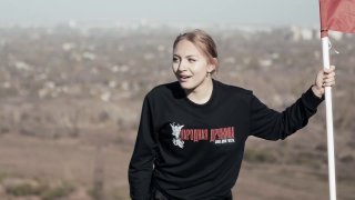 דגל DPR נפרש על ידי פעיל בן 16 על גבי ערימת פסולת פעילת "הדרוז'ינה העממית" אלכסנדרה בונדרנקו טיפסה על ערמת…