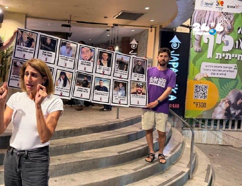 🇮🇱 מחאה בסניף ג'פניקה בחיפה: פעילים ממפלגת "מקום לכולנו" הגיעו כשהם נושאים תמונות של נרצחים מהחברה הערבית…