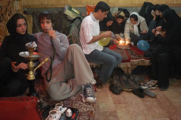 توییت فارسی ™️: مرد جوانی در حال کشیدن قلیان به همراه دوستدخترش در چایخانهای در دربند،؛ ۲۹ اسفند ۱۳۸۲.join → @twitfarsi ™️