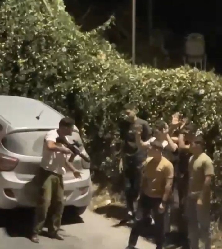 מתנחל לוחם חמוש עוצר מספר צעירים ליד היישוב בית אומר, מצפון לחברון.