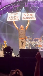 American singer Dave Matthews holds up banners demanding "stop the genocide" and "stop killing children" in Gaza.