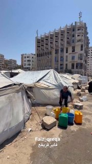 نازح يرش المياه على خيمته وسط أزمة صحية في غزة