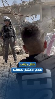 A child watches the demolition of the occupation's house in "Halat al-Humous" in Safar Yatta, south of Hebron.