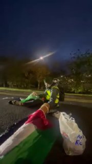 פעילי אנשים נגד רצח עם חוסמים את הכביש מחוץ למרכז ההפצה של DSV בסטוק-און-טרנט, סטפורדשייר, אנגליה, במחאה על…