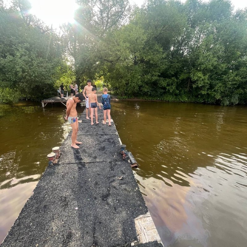 В Хлебниково на берегу самострой причала, пришвартованные корабли и дебаркадер.