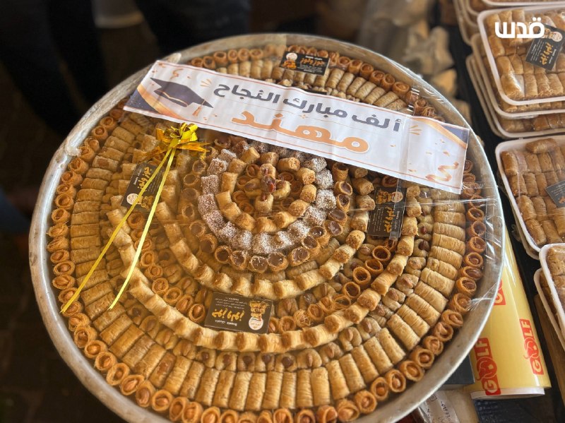 למרות טרגדיית המלחמה והסבל המתמשך, פלסטינים קונים ממתקים בעיר חאן יונס, ערב ההכרזה על תוצאות התיכון "טוג'יהי".