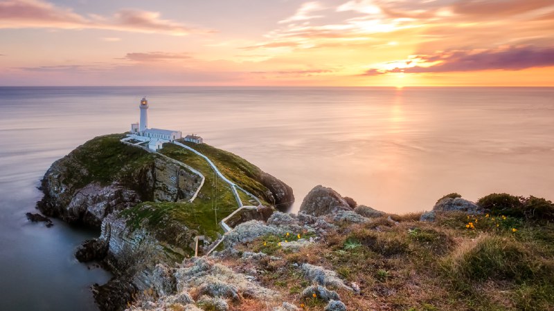 High tides and bright lightsSouth Stack Lighthouse at sunset, Holy Island, Wales (© mariotlr/Getty Images)