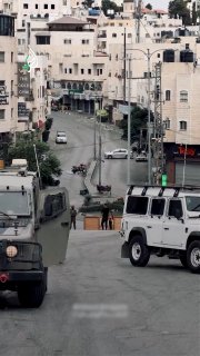 כוחות ישראל עוצרים גבר וילדה במחסום צבאי בעיר חברון
