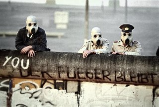 East German border guards watch as tear gas is used to disperse demonstrators on the other side of the Berlin Wall. GDR and FRG, 1988.Time Machine | Historical Photo