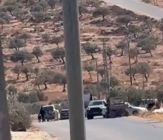 Settlers accompanied by the IDF block the road in front of residents near the village of al-Taiba, east of Ramallah.
