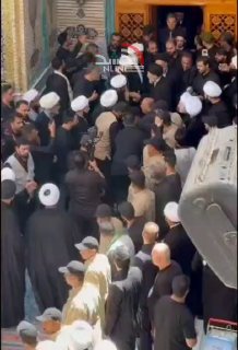 🎦 האייתוללה סייד מוחמד תק'י אל-חכים נכנס למקדש האימאם עלי (אס) כדי להתפלל מעל גופתו של מנהיג האומה שנהרג.