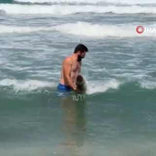 אדם בסינופ, טורקיה שולף גליל חלוד בצורת טיל מהים השחור ונשא אותו כלאחר יד על החוף.