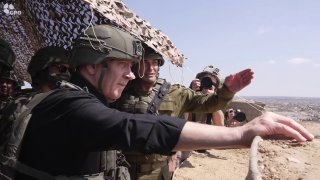 נתניהו, מוקף בחיילים ישראלים, צופה בהריסות עזה שהרס.