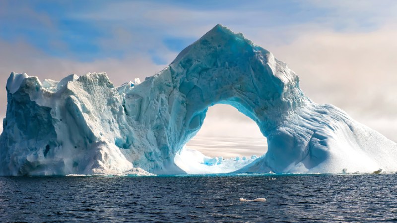 Where ice holds its breathNatural arch carved in an iceberg, Antarctica (© Gabrielle/Adobe Stock)