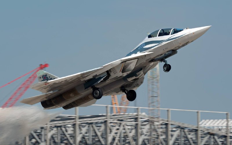 🇷🇺️ — תמונה של מטוס Su-57D ממריא משדה התעופה Ramenskoye במחוז מוסקבה, כשברקע כמה האנגרים גדולים בבנייה.