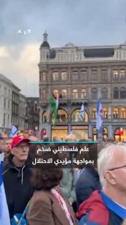 This angered the supporters of the occupation and they tried to destroy it. Activists raise a huge Palestinian flag from a shop window at Dam Square in the Dutch capital, Amsterdam, during a pro-Israel demonstration.