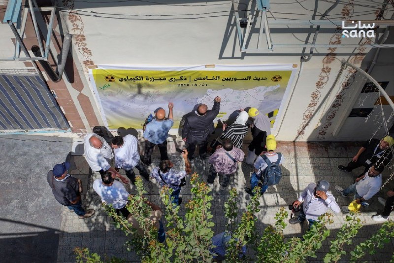 משתתפי פורום "דיבור סורי" החמישי בעיירה זמלקה באזור הכפרי של דמשק חותמים על שלט "סוריה", לציון יום השנה ה-1…