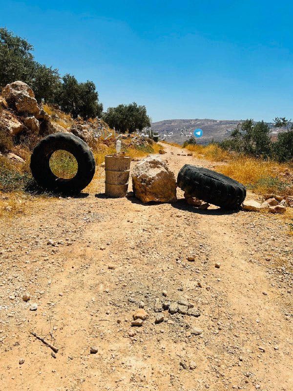 צעירים חוסמים כביש לעיני מתנחלים לאחר שגורשו מהמקום בפאתי הכפר אל-מוג'יר, צפונית מזרחית לרמאללה.
