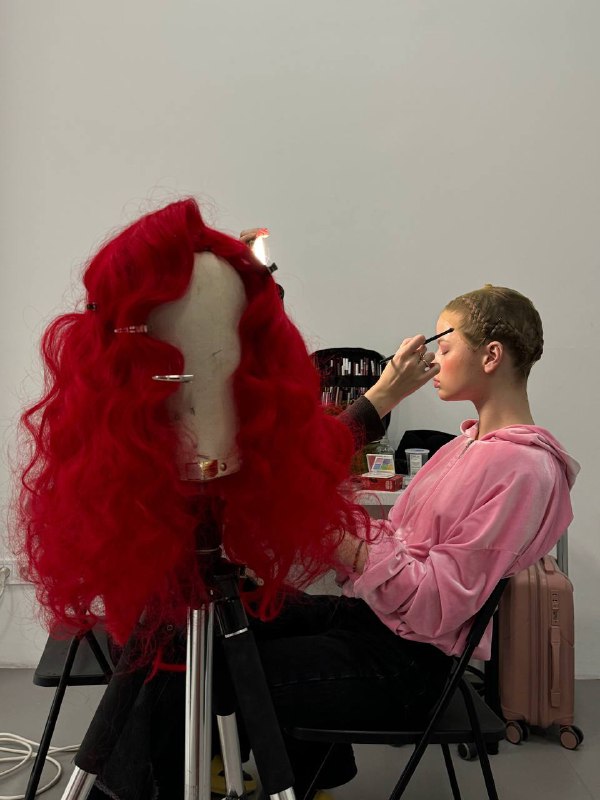 Парик для съемки к 14 февраляДля нашей съемки ко Дню всех влюбленных я решила использовать насыщено-красные волосы. Из доступных ко дню опций был только прямой искусственный парик. Стараюсь находить самые удобные «накрученные» варианты при покупке, но не в этот раз. Предо мной встала задача реализовать идею укладки с нуля. Напомню, волосы искусственные. Парик выглядел не капризным, но по итогу горячие инструменты не подошли для создания стойких локонов. Зато с помощью бигуди получилось создать кудри — пышные и очерченные.Процесс был не быстрым: я аккуратно завиваю прядь за прядью, добиваясь нужной текстуры — около 2 часов. Затем работа с вычесом с помощью большой щеткой с щетиной, в поисках идеального направления. В конце работы фиксация вычесанной формы у лица с помощью клеммов. На самой съемке изолируем волосы модели под капроновую шапочку.Парик для съемки к 14 февраляДля нашей съемки ко Дню всех влюбленных я решила использовать насыщено-красные волосы. Из доступных ко дню опций был только прямой искусственный парик. Стараюсь находить самые удобные «накрученные» варианты при покупке, но не в этот раз. Предо мной встала задача реализовать идею укладки с нуля. Напомню, волосы искусственные. Парик выглядел не капризным, но по итогу горячие инструменты не подошли для создания стойких локонов. Зато с помощью бигуди получилось создать кудри — пышные и очерченные.Процесс был не быстрым: я аккуратно завиваю прядь за прядью, добиваясь нужной текстуры — около 2 часов. Затем работа с вычесом с помощью большой щеткой с щетиной, в поисках идеального направления. В конце работы фиксация вычесанной формы у лица с помощью клеммов. На самой съемке изолируем волосы модели под капроновую шапочку.