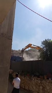 ג'מיל נג'ג'רה הפלסטיני קורא את הקוראן ומתפלל לאלוהים במהלך הריסת ביתו בכיבוש בעיירה נחלין, מערבית לבית לחם.