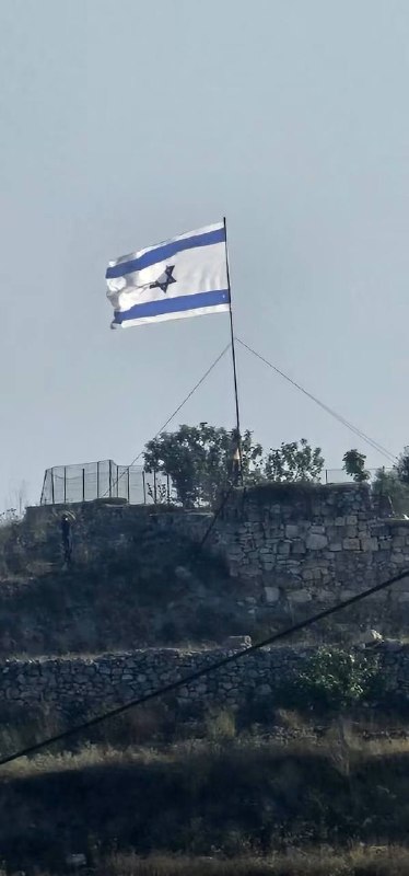מתנחלים מרימים את דגל הכיבוש כשהם מסתערים על האזור המערבי של הכפר דיר עמאר, ממערב לרמאללה.