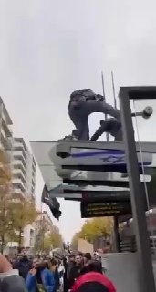 המפגינים שורפים דגל ישראלי ואמריקאי על גבי חופת תחנת החשמלית בכיכר ז'אן מאסט בעיר ליון שבצרפת. ביו.קישור/al…