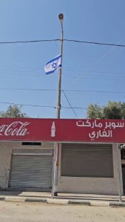 مستوطنون يرفعون أعلام إسرائيلية على طريق في جنين