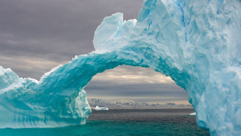 An ocean's frozen cathedralArched iceberg floating off the western Antarctic Peninsula, Southern Ocean (© Steven Kazlowski/Nature Picture Library)