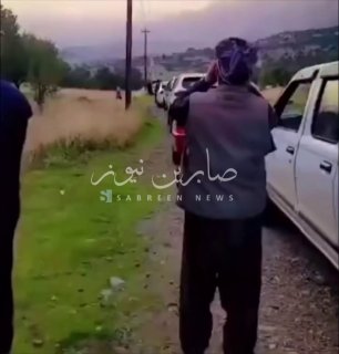 A Kurdish citizen in Shiladzi district of Amadiya district in Dohuk governorate uses binoculars to investigate the end of the queue in front of a gas station.