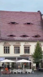 In Sibiu, Romania, the rooftops watch like half-closed eyes.