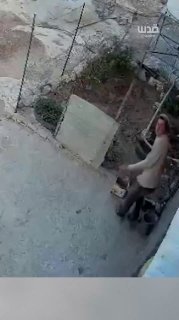 A settler steals a shoe in front of a Palestinian residence in Safar Yatta, south of Hebron